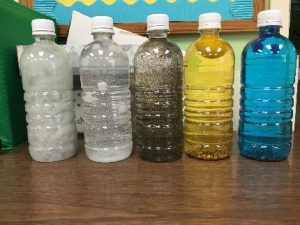 picture of water bottles with different colors of dye. 