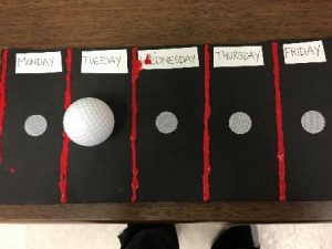 picture of a felt calendar board with a textured ping pong ball that moves for whichever day of the week. 