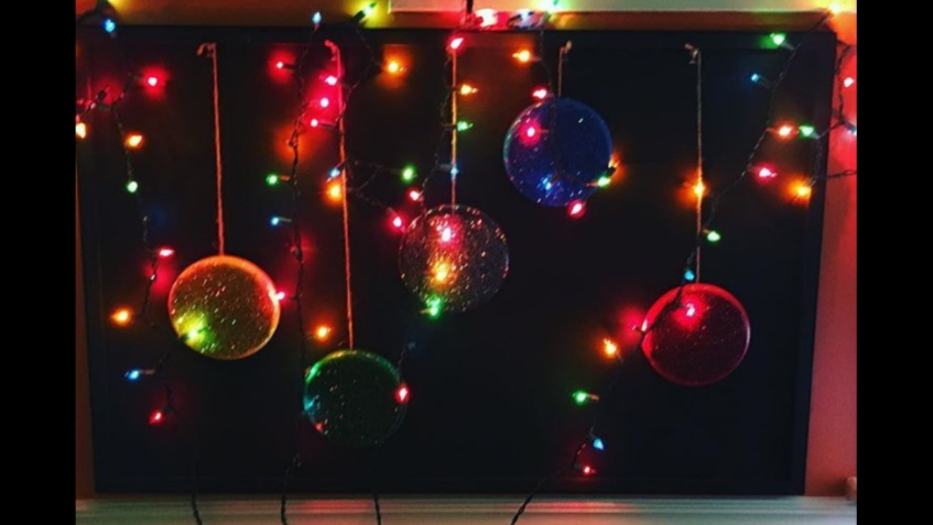 picture of a sensory wall made with blacklighting, Ablenet Switch covers, and christmas lights.