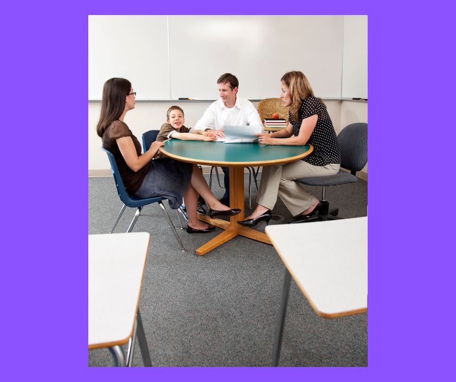 Mother, father and child sitting at a table with teacher